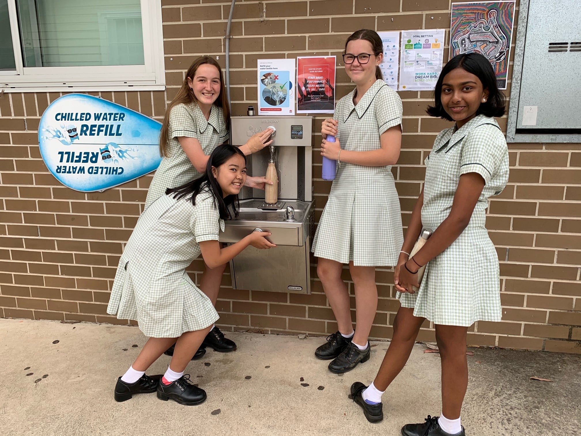 East Hills Girls' Technology High School students Yuthara Attanayake, Kieu-Jacey Nguyen, Olivia Petersen and Jenna Shaw fill up their water bottles at the school's new chilled water station.