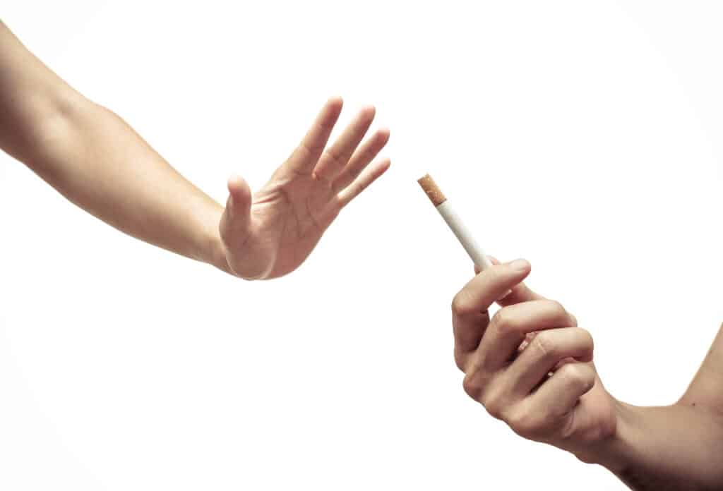 A hand out in a no motion declining a cigarette being offered.