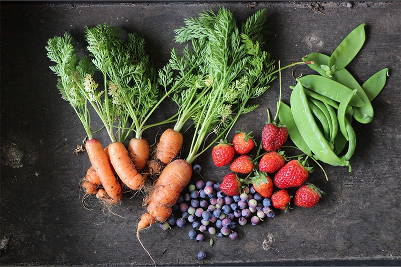 Fruit and vegetable sof a variety of colours laid out on a table.