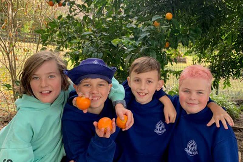 School children from Empire Bay Public School holding orange.