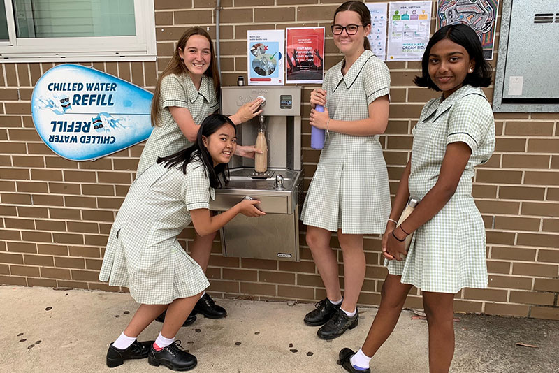 East Hills Girls' Technology High School students Yuthara Attanayake, Kieu-Jacey Nguyen, Olivia Petersen and Jenna Shaw fill up their water bottles at the school's new chilled water station.