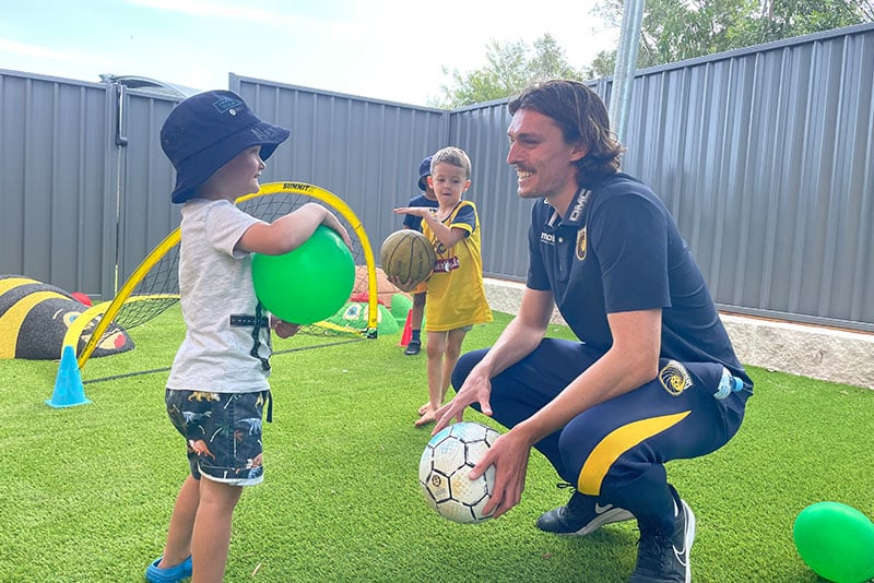 Central Coast Mariners defender Cameron Windust with children from Kariong Childcare Centre.