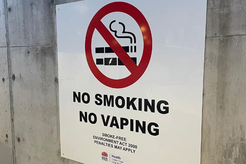 A Central Coast Local Health District sign reading NO SMOKING NO VAPING and noting penalties apply.