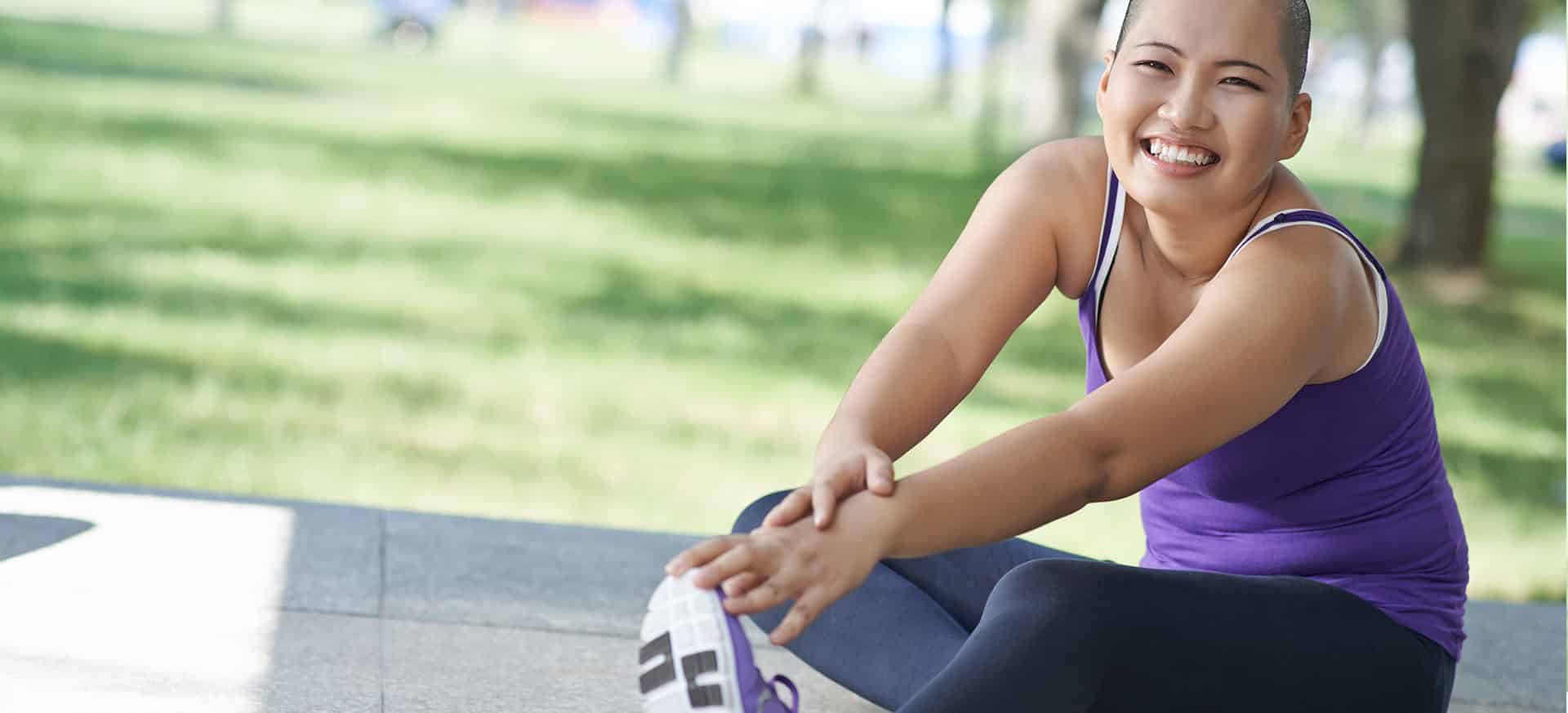 A young Asian woman stretching in active wear.