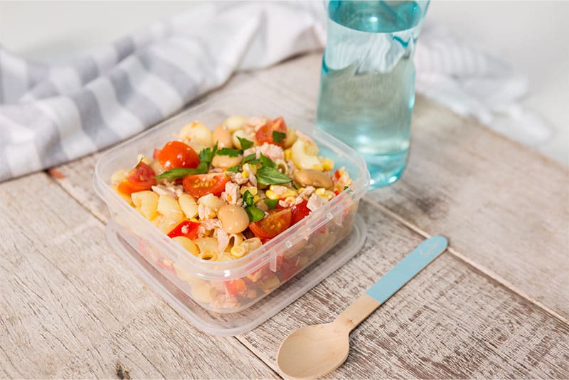 A healthy pre-prepared meal in tupperware and bottle of water.