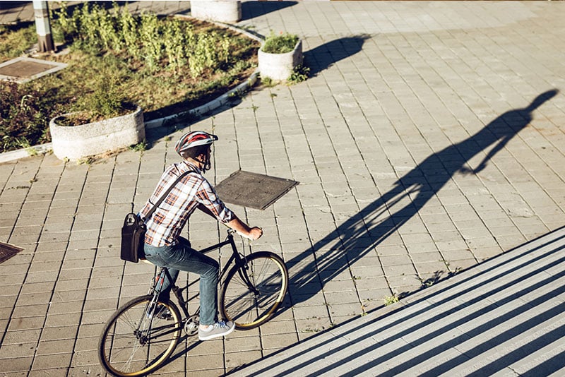 A man with satchel cycling.