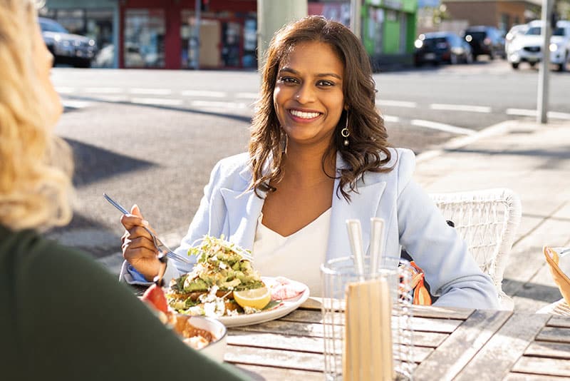 A young woman eating food at a Central Coast cafe.