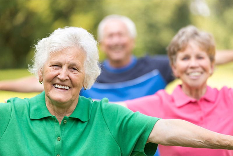 Older adults doing balance exercises outdoors.