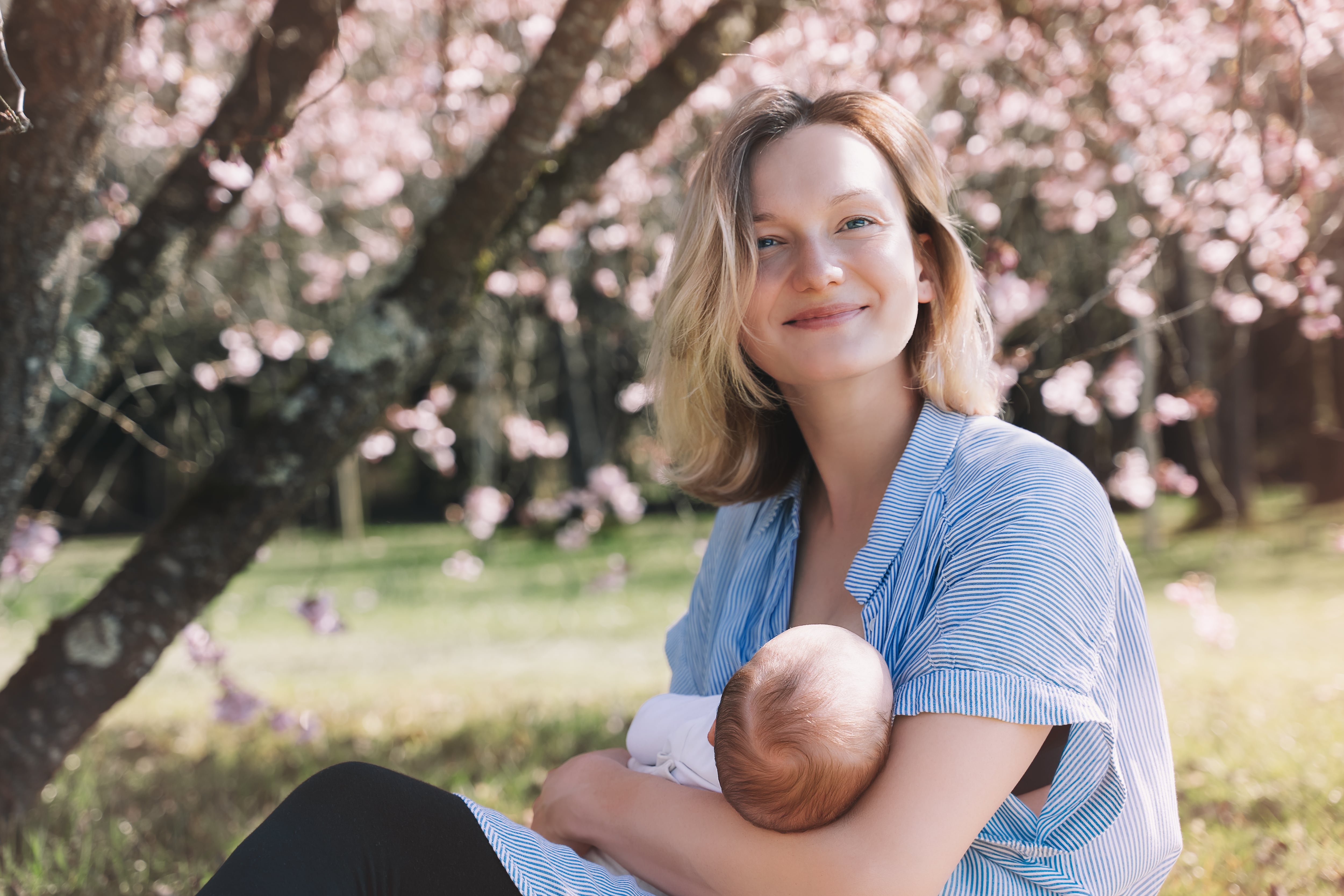 A mother breastfeeding outdoors.