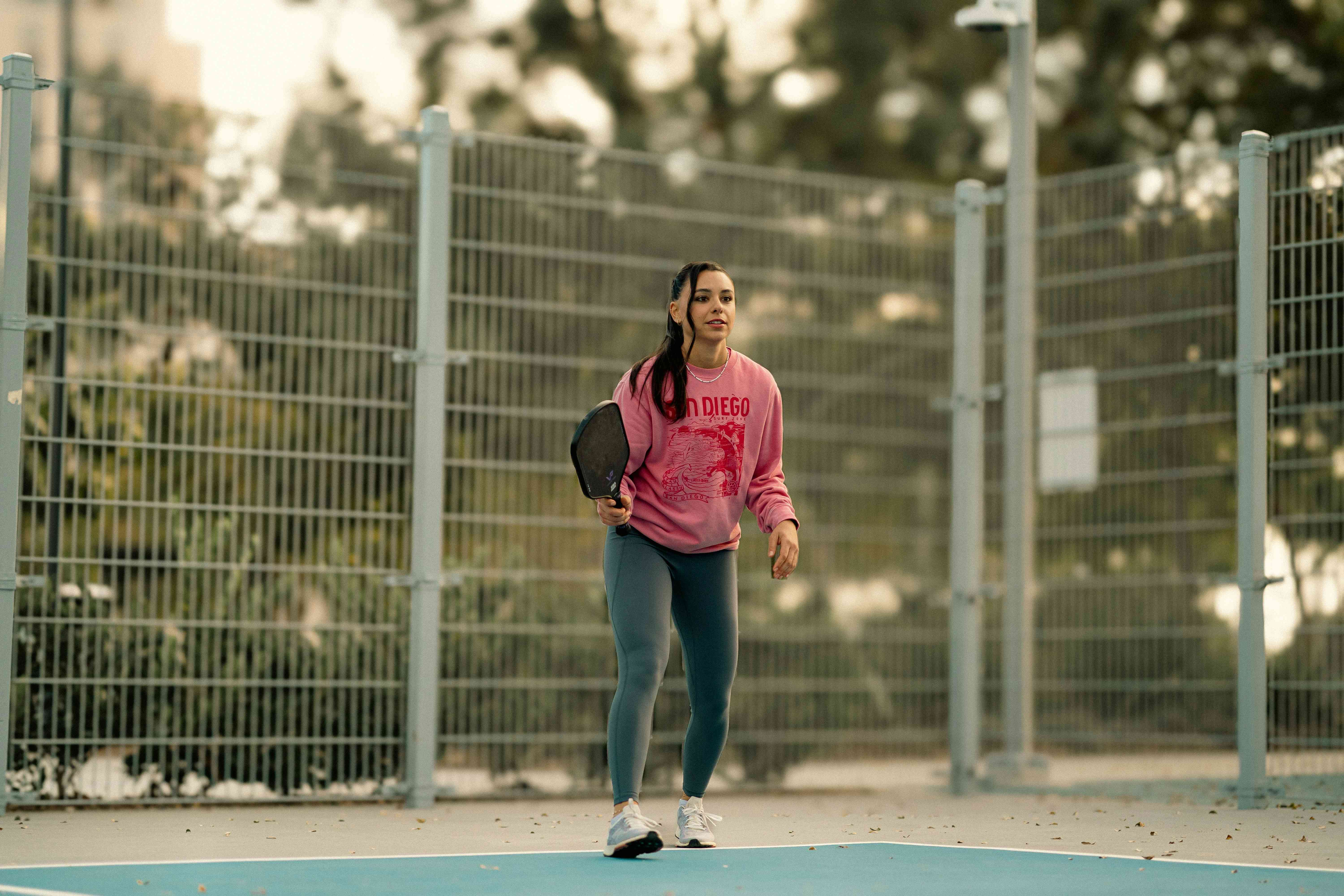 A teenage girl playing pickleball.