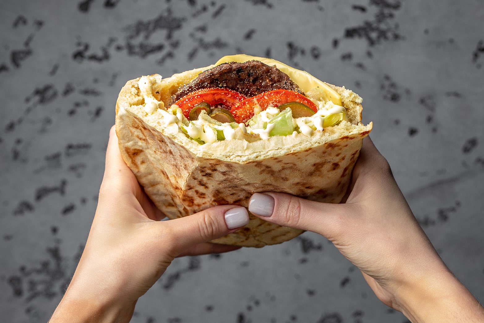 Female hands holding Kebab Doner Kebap juicy cutlet and vegetables. fast food.