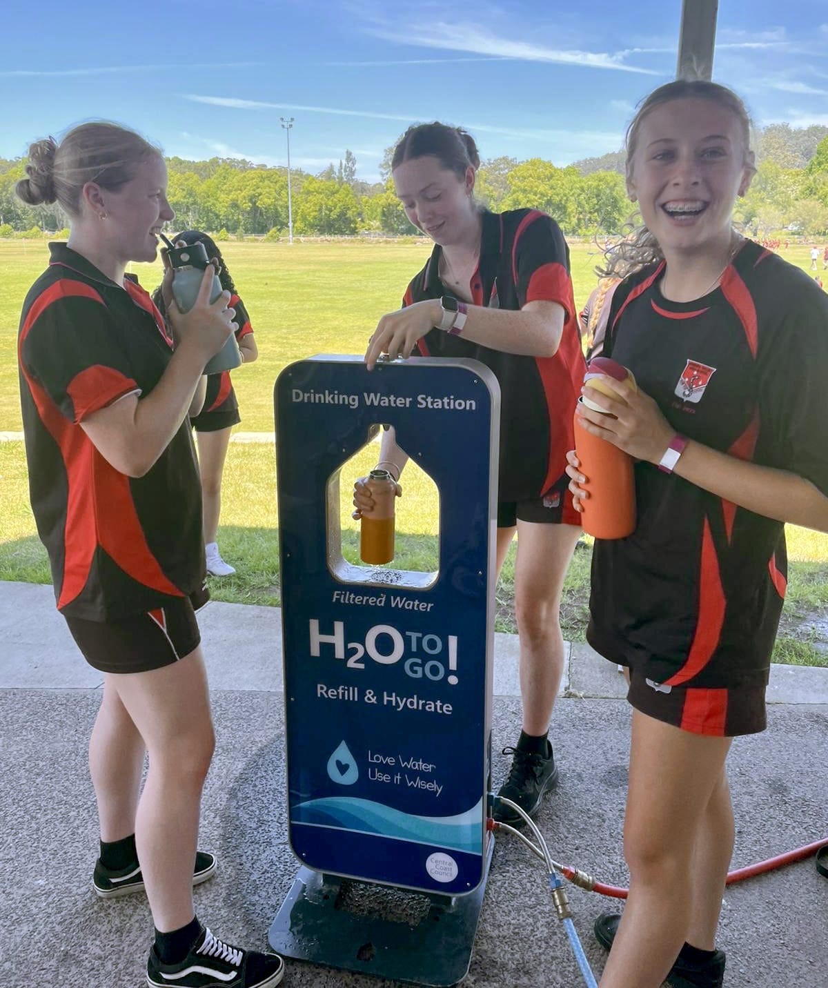 Girls at portable water station filling up drink bottles