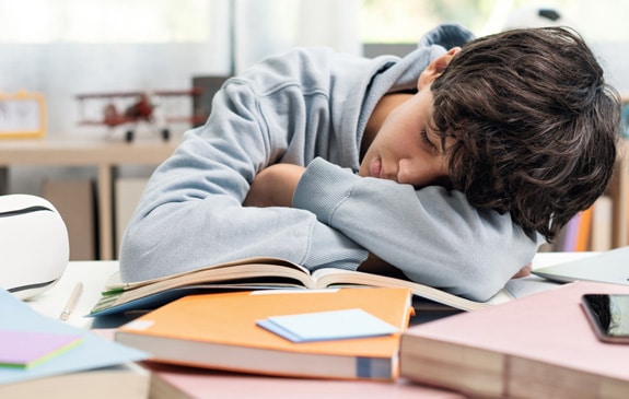 teenager boy asleep at desk