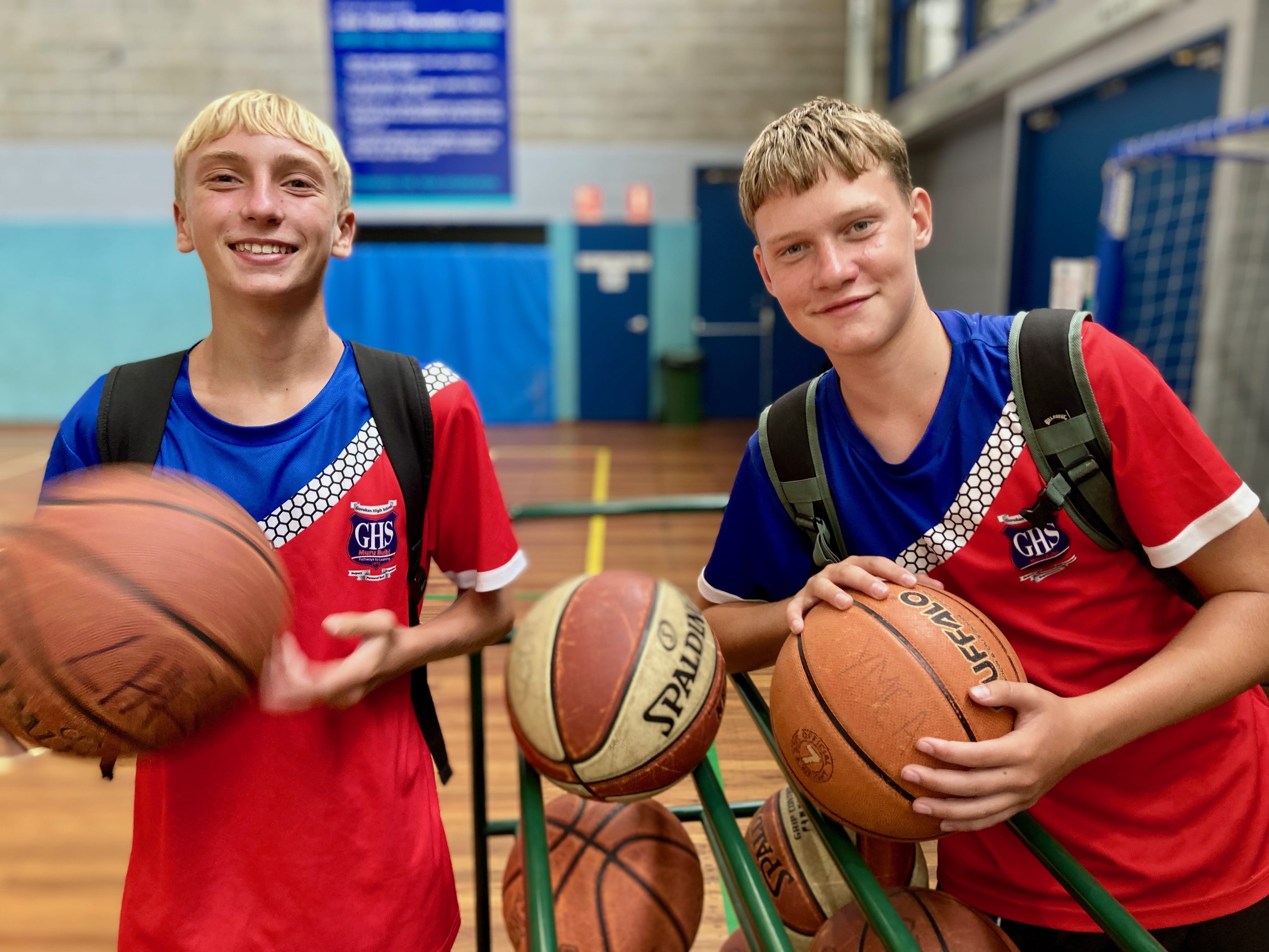 two boys holding basketballs on a basketball court from the YMCA NSW Streetgym Program