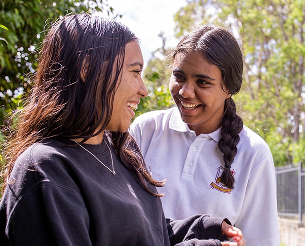 two Aboriginal high school girls smiling and talking