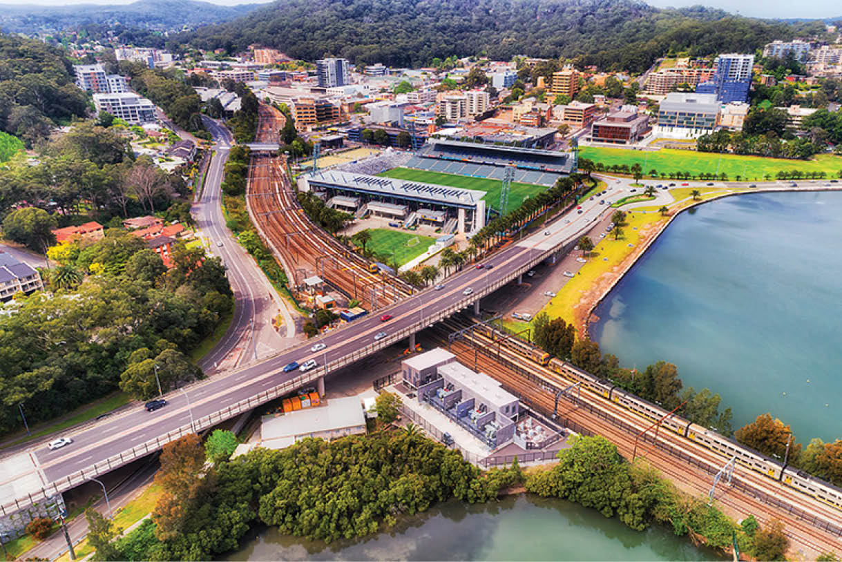 Gosford town CBD on Australian Central coast around train station and intersection of Central coast highway and railway with waterfront of Brisbane water - elevated aerial top down view.